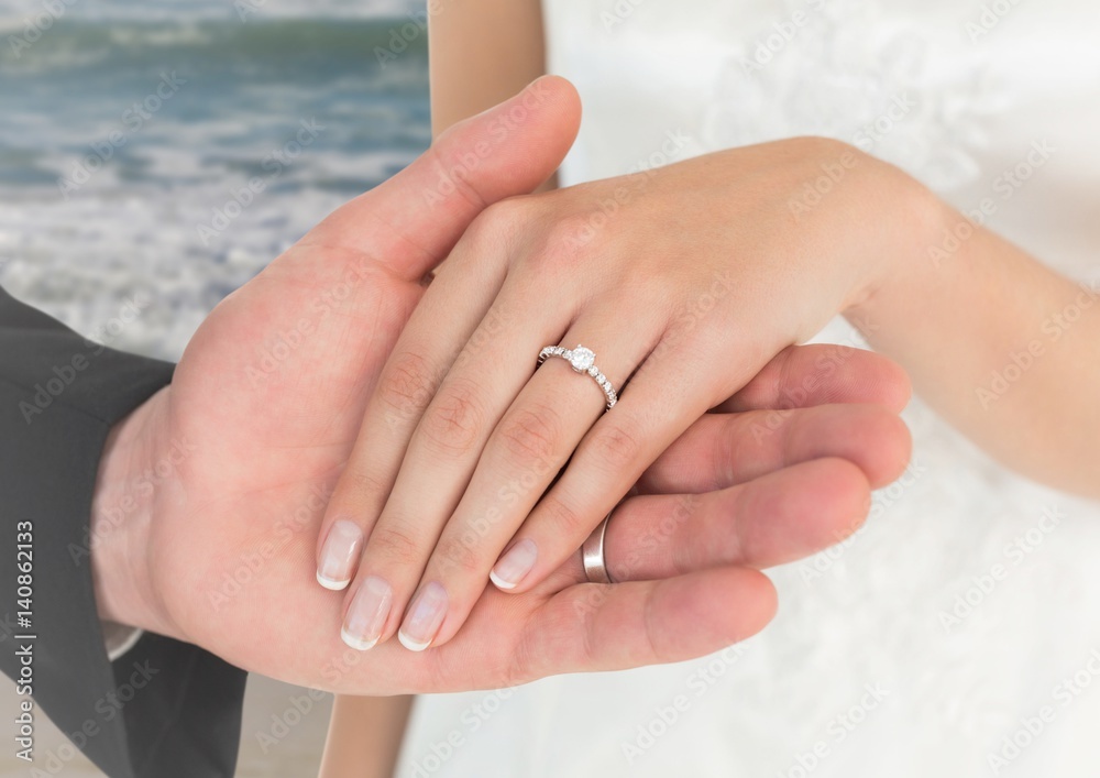 Newly wed couple holding hands on beach Newly wed couple holding hands on beach