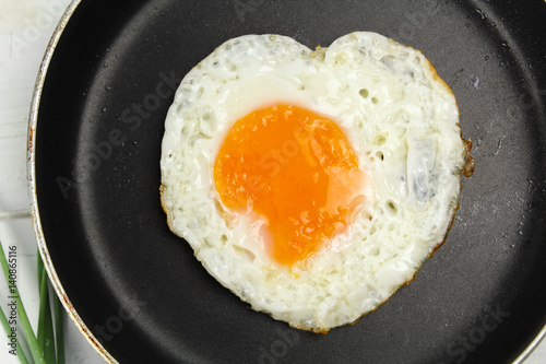 fried egg heart-shaped for breakfast on plate