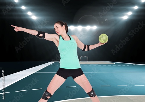 Female handball player throwing ball at handball court