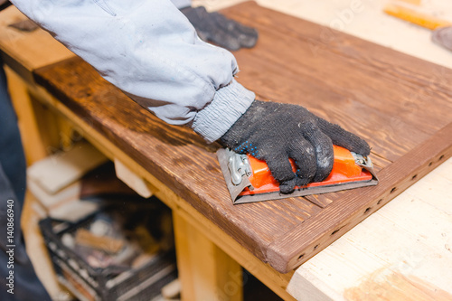 Wallpaper Mural The man grinds wood. The joiner processes wooden boards. Joiner's works of the house. Torontodigital.ca
