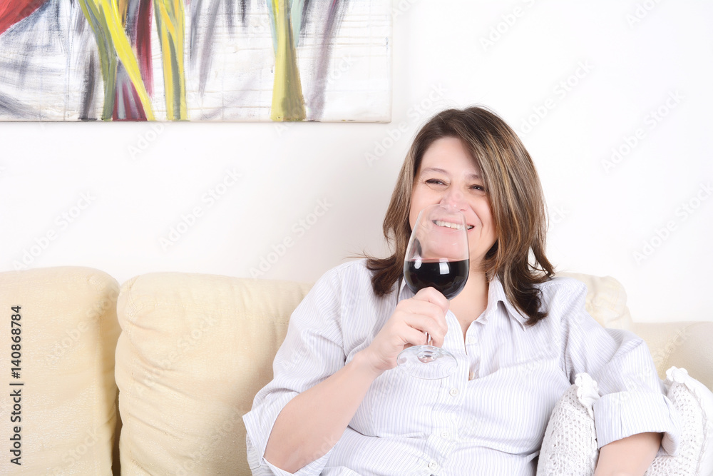 Woman relaxed on sofa with a glass of wine. Woman relaxed on sofa with a glass of wine.