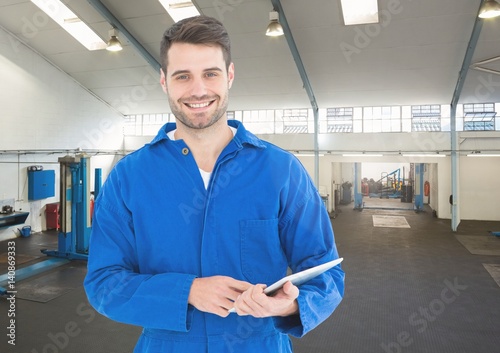 Mechanic holding digital tablet in garage