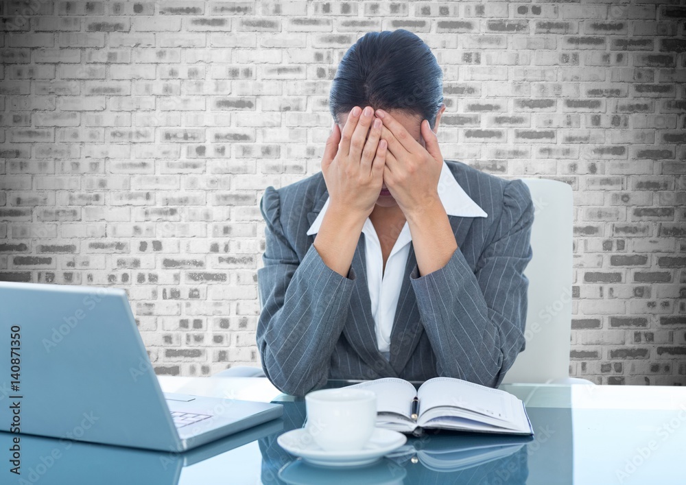 Depressed businesswoman sitting at desk with laptop and diary Depressed businesswoman sitting at desk with laptop and diary