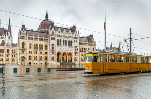 yellow Budapest tram in front of Hungarian National Parliament