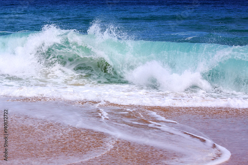 Splashing wave on the beach photo