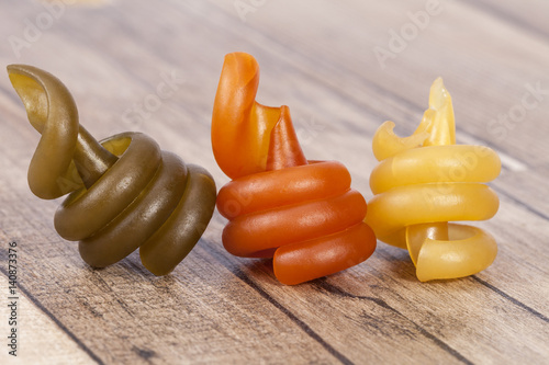 Spiral pasta trottole tricolore isolated on wooden plank photo