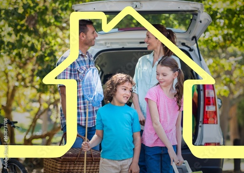 Happy family standing next to car