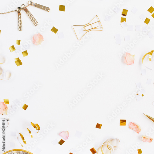 Beauty blog background. Gold style feminine accessories frame. Golden tinsel, scissors, pen, rings, necklace, bracelet on white background. Flat lay, top view.