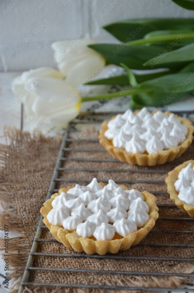 Tartlets with merengue on a stand with lemon jam, still life. romantic morning Tartlets with merengue on a stand with lemon jam, still life. romantic morning