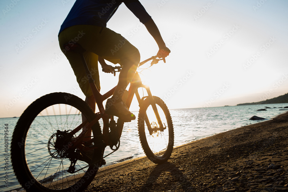 Man riding a mountain bike on the beach