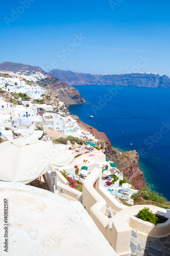 View of Fira town - Santorini island Crete Greece. White concrete staircases leading down to beautiful bay with clear blue sky and sea