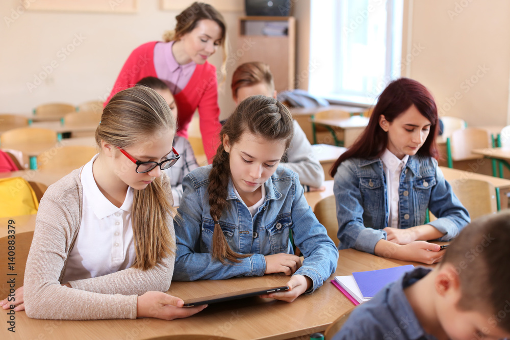 Pupils and teacher in classroom working with tablet computer