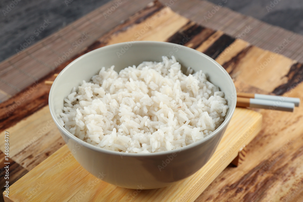 Bowl of rice and chopsticks on wooden table Bowl of rice and chopsticks on wooden table