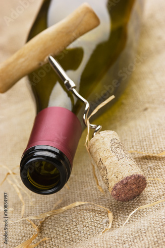 wine bottle and corkscrew on a canvas