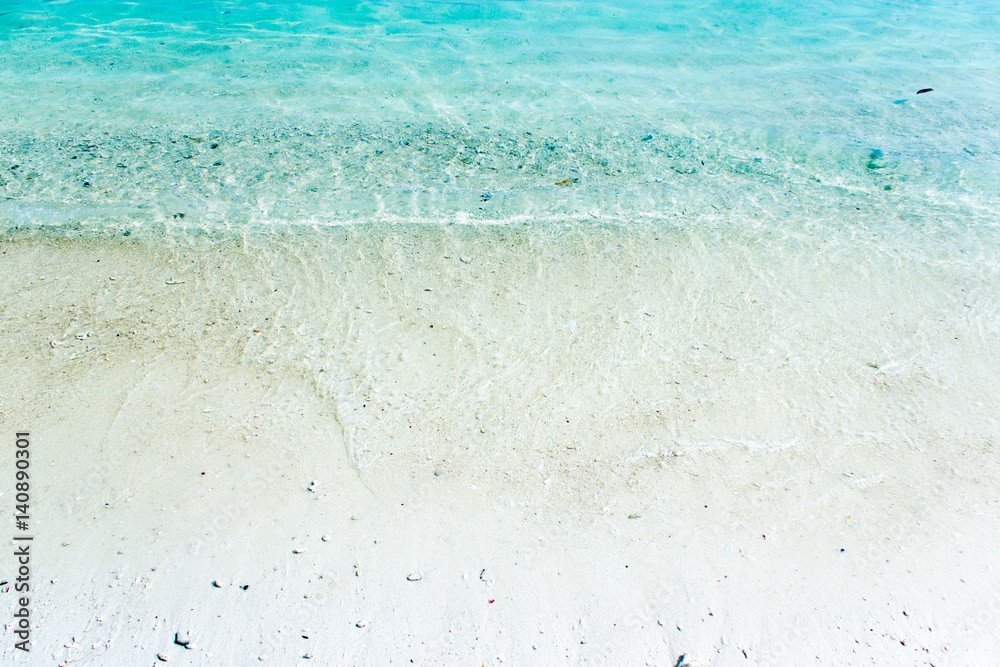 white sand with blue green waves on the beach