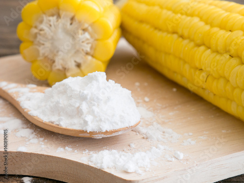 Corn flour in spoon on wooden.