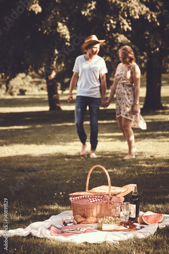 Barefoot young couple enjoying a picnic in a park photo