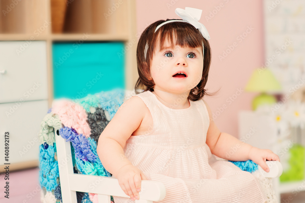 cute happy 1 year old baby girl playing with wooden toys at home
