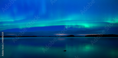 Northern lights dancing over calm lake  Aurora borealis 