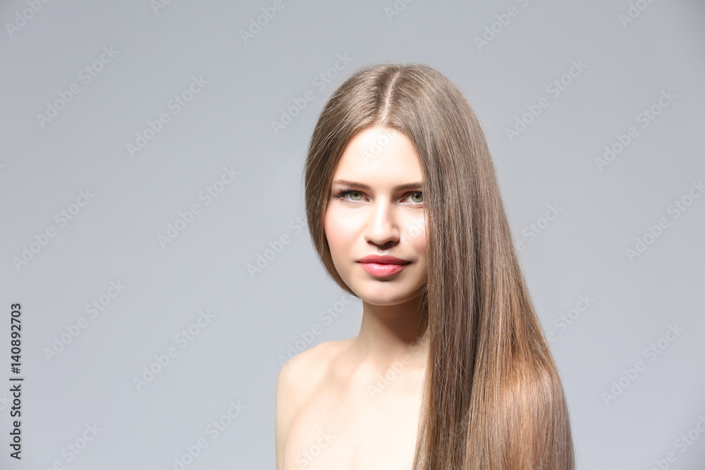Attractive young woman with beautiful long hair on light background Attractive young woman with beautiful long hair on light background