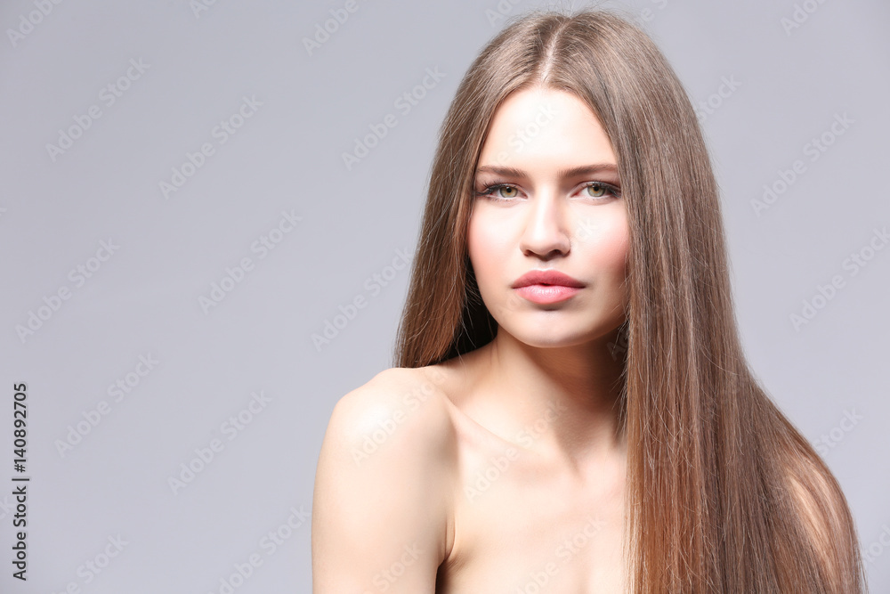 Attractive young woman with beautiful long hair on light background Attractive young woman with beautiful long hair on light background