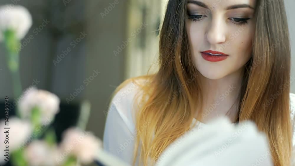 Pretty brunette looks satisfied while reading book in the cafe, steadycam shot
Pretty brunette looks satisfied while reading book in the cafe, steadycam shot