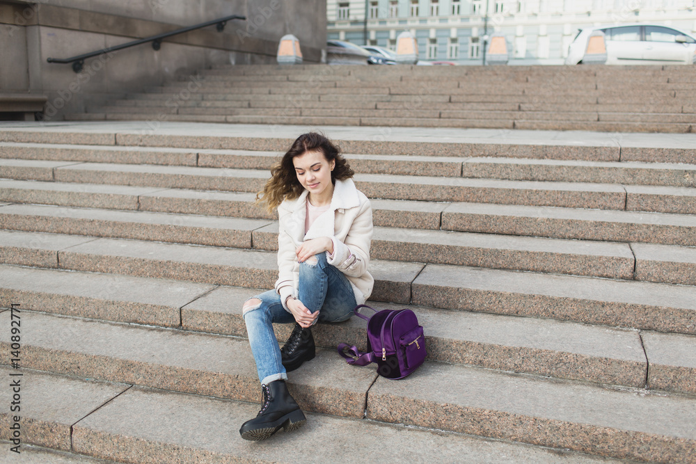 Sad girl sitting on the steps of the theater Sad girl sitting on the steps of the theater