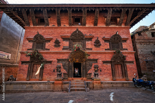 Traditional nepalese newar red brick house with wooden carvings on it in Bhaktapur, Nepal photo