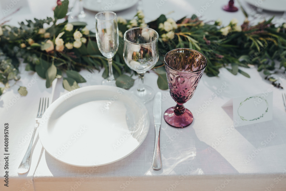Festive table served dishes and decorated with branches of greenery, stands on green grass in the area of wedding party Festive table served dishes and decorated with branches of greenery, stands on green grass in the area of wedding party