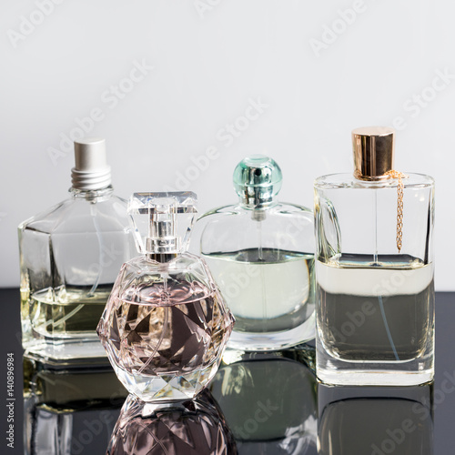 Different perfume bottles with reflections. Perfumery, cosmetics.