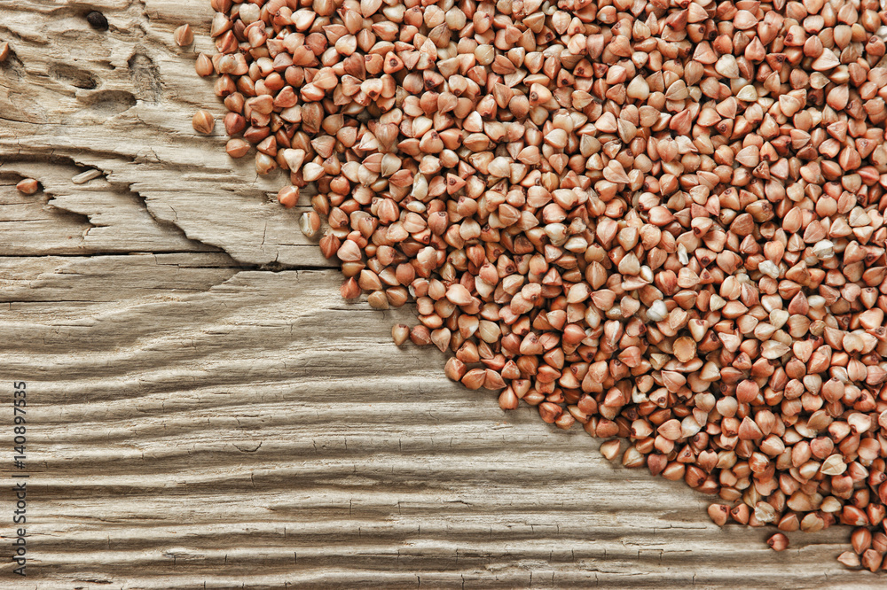 Obraz premium buckwheat groats on a wooden table