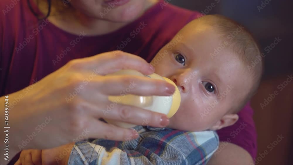 mother feeding son. Closeup. Happy newborn relish drinking milk. Caucasian boy with blue eyes looking at the camera. mother feeding son. Closeup. Happy newborn relish drinking milk. Caucasian boy with blue eyes looking at the camera.