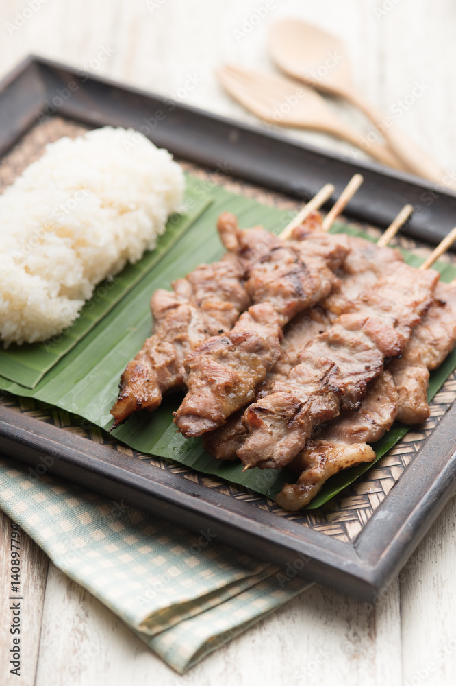 Thai styled grilled pork and sticky rice on wood