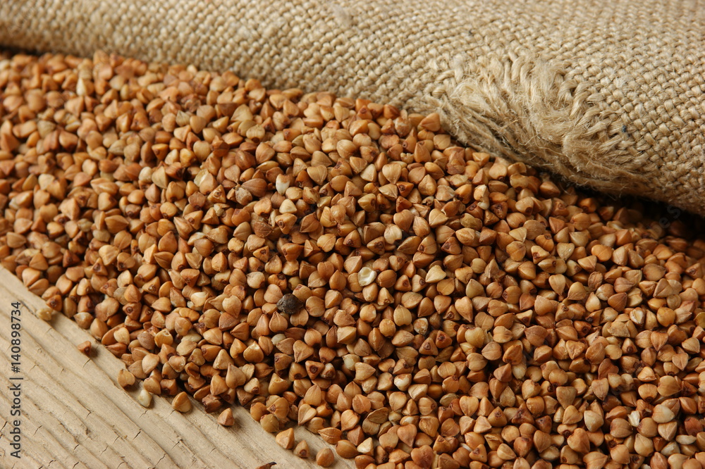 Obraz premium buckwheat groats on a wooden table