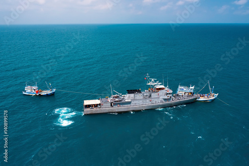 Military navy ships in a sea bay with fishing boat,view from aerial