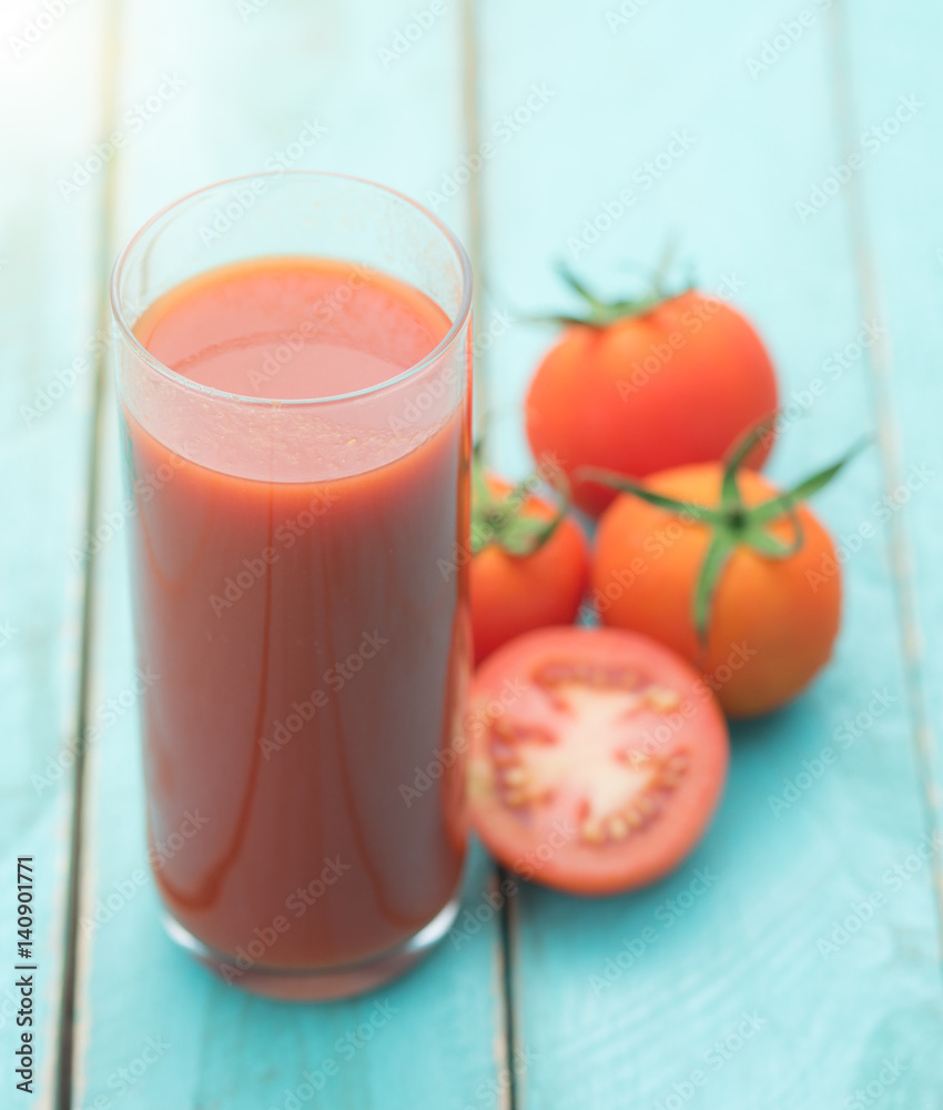 Glass of tomato juice on blue wooden table Glass of tomato juice on blue wooden table