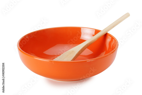 orange empty ceramic bowl and wooden spoon  isolated on white background