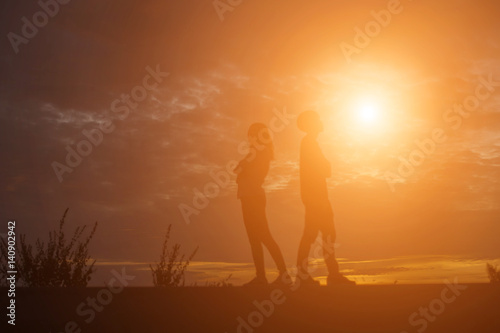 Men and women standing behind on sunset © Chittakon