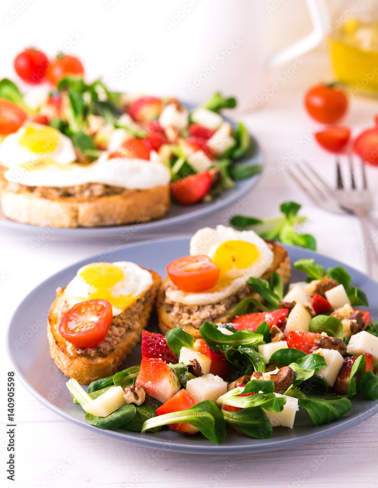 Salad with strawberry, spinach and goat cheese.  Bruschettes