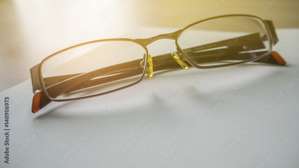 eyeglasses spiral notebook lying on a dark brown wooden desk eyeglasses spiral notebook lying on a dark brown wooden desk
