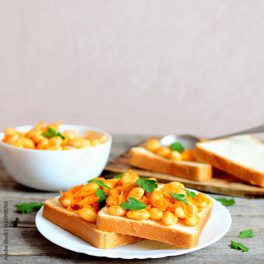 Vegetarian open sandwiches on a plate. Stewed white beans with vegetables and parsley on white bread slices. Healthiest food Vegetarian open sandwiches on a plate. Stewed white beans with vegetables and parsley on white bread slices. Healthiest food