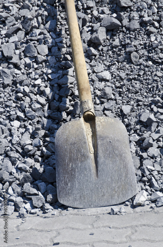 Schaufel vor grauem Splitt - Symbolfoto für Arbeit