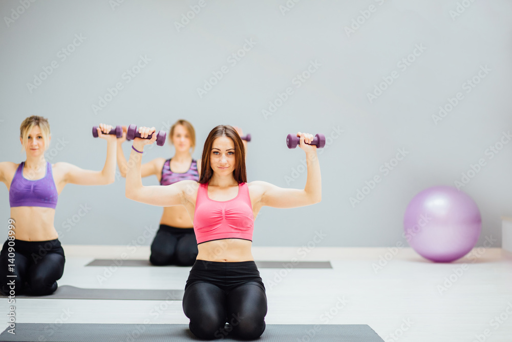 Group Of Three Women doingexercise with dumbbell.