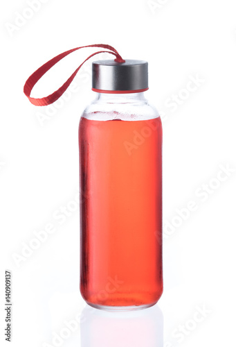 Red energy drink in glass bottle isolated on white