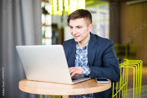 Handsome businessman working with laptop in office