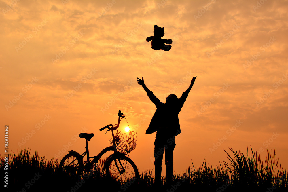 Silhouette of girl with bicycle on grass field at the sky sunset, color of vintage tone and soft focus concept journey Silhouette of girl with bicycle on grass field at the sky sunset, color of vintage tone and soft focus concept journey