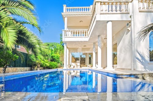 Luxury white house  with swimming pool. Luxury villa in classical style with columns.  Backyard with swimming pool in mansion. © steftach