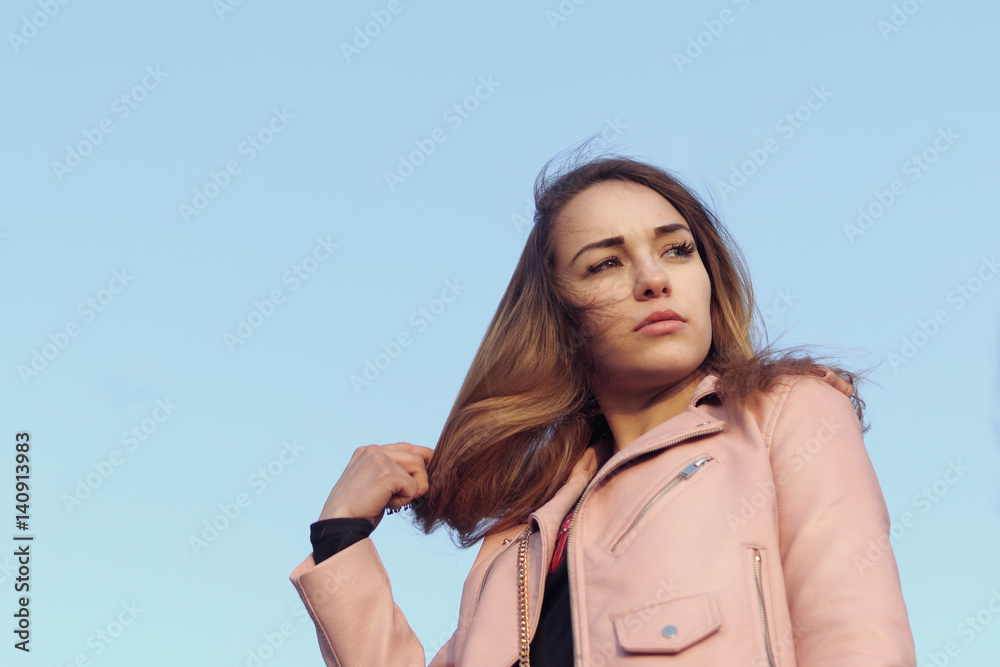 Fashion portrait of a beautiful girl against a blue sky Fashion portrait of a beautiful girl against a blue sky