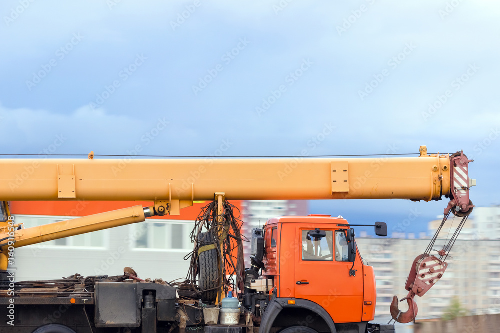 Truck crane drive on the road against the background of the city Truck crane drive on the road against the background of the city