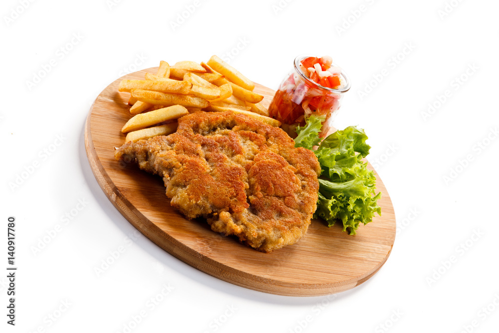 Fried pork chop with french fries on cutting board Fried pork chop with french fries on cutting board